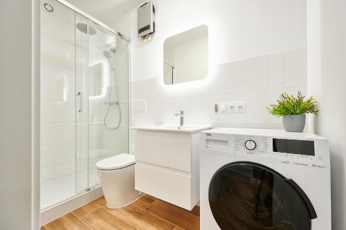 a white bathroom with a washing machine and a sink at Apartament Barczewski, 2 pokoje i kuchnia in Olsztyn