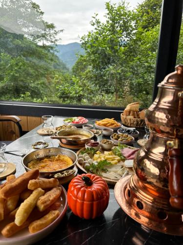 a table topped with plates of food and a pumpkin at Maysa Suit Bungalov in Çamlıhemşin