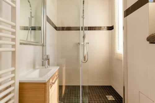 une salle de bain avec douche et lavabo dans l'établissement Cozy studio near Montmartre, à Paris