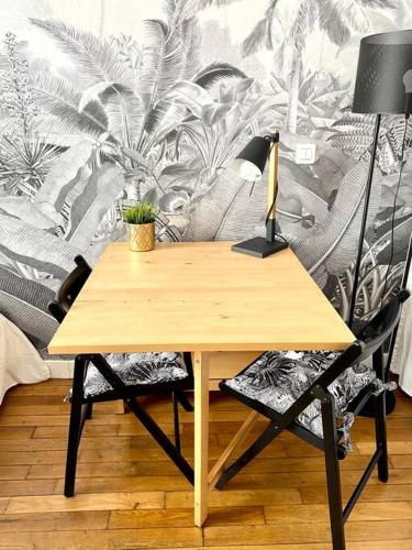 un bureau en bois avec une lampe et une chaise dans l'établissement Cozy studio near Montmartre, à Paris