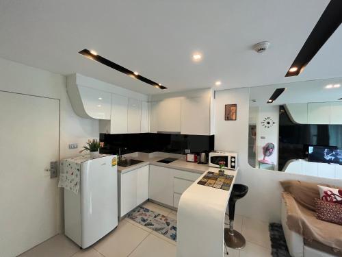a kitchen with white cabinets and a white refrigerator at City center residents Pool view in Pattaya