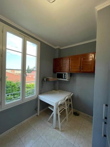 une petite cuisine avec une table et une fenêtre dans l'établissement Nice Riviera Fabulous Seaside Apartment with 3 Bedrooms, à Nice