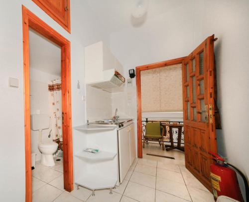 uma cozinha com um lavatório, um WC e uma porta em Michalis Studios em Leipsoi
