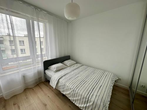 a white bedroom with a bed and a window at SDH 4 Radzymin comfortable apartment near Warsaw in Radzymin