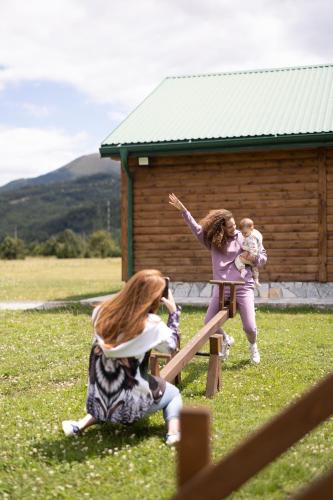 a group of children playing on a wooden playground at Eco Village & Chalets Green Heaven in Mojkovac