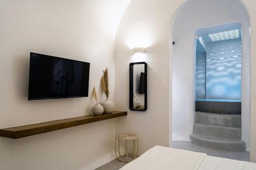ein Wohnzimmer mit einem Flachbild-TV an der Wand in der Unterkunft Wonderful Santorini Villa 1 Bedroom Villa Gonia Astonishing Views and Outdoor Jacuzzi Exo Gonia in Éxo Goniá