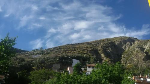 a view of a mountain with trees and buildings at Rincón de María José in Monachil