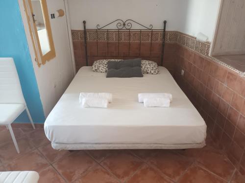 a bed in a room with two pillows on it at Pension El Torreon in Mojácar