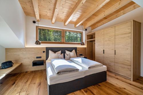 a bedroom with a large bed and wooden floors at Wiesgut Ferienwohnung Gala in Tesimo