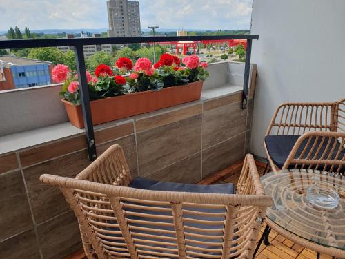 a balcony with a table and chairs and flowers at LANE City Laatzen in Hannover