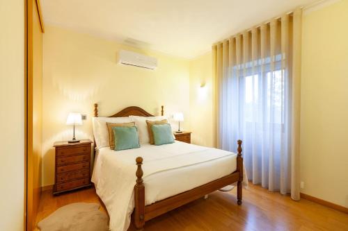 sypialnia z dużym łóżkiem i oknem w obiekcie Casa da Tomada - Minho's Guest w mieście Braga