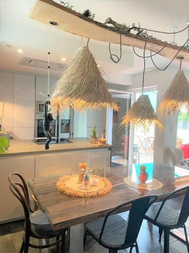 une cuisine avec une table en bois et des chaises ainsi qu'une salle à manger dans l'établissement A la villa du voyageur - proche Europa Park, Strasbourg et Colmar, à Sélestat