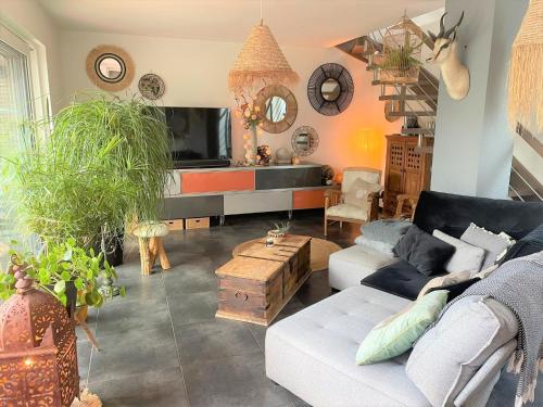 sala de estar con sofá y TV en A la villa du voyageur - proche Europa Park, Strasbourg et Colmar en Sélestat