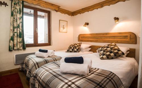 um quarto com 2 camas e toalhas em Chalet Barragiste em Courchevel