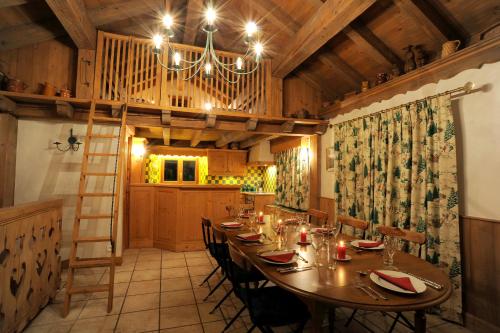uma sala de jantar com uma mesa longa e um lustre em Chalet Barragiste em Courchevel