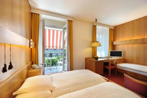 a bedroom with a bed and a desk with a computer at Elite in Lausanne