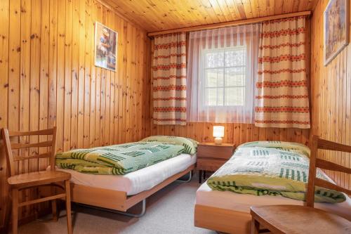 Ce lit se trouve dans un dortoir doté de murs en bois et d'une fenêtre. dans l'établissement Alouette Ost, à Bettmeralp