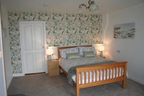 a bedroom with a bed with a floral wallpaper at Swallows Rest in Annascaul