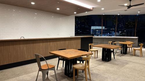 a restaurant with wooden tables and chairs and a counter at Panoramic KL View @Robertson Bukit Bintang 40f in Kuala Lumpur