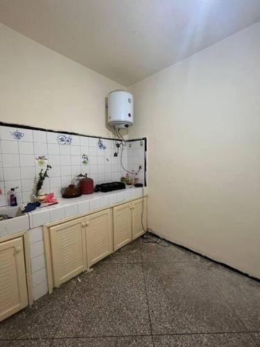شقة للكراء اليومي و الشهري في أغادير: مطبخ بجدران بيضاء ومغسلة في الغرفة