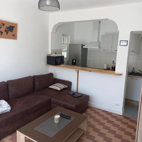 un salon avec un canapé marron et une table dans l'établissement Maison 2 chambres, à Saint-Palais-sur-Mer