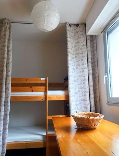 - une chambre avec des lits superposés, une table et un panier dans l'établissement Gérardmer Centre - Studio au pied du lac Grande terrasse, à Gérardmer