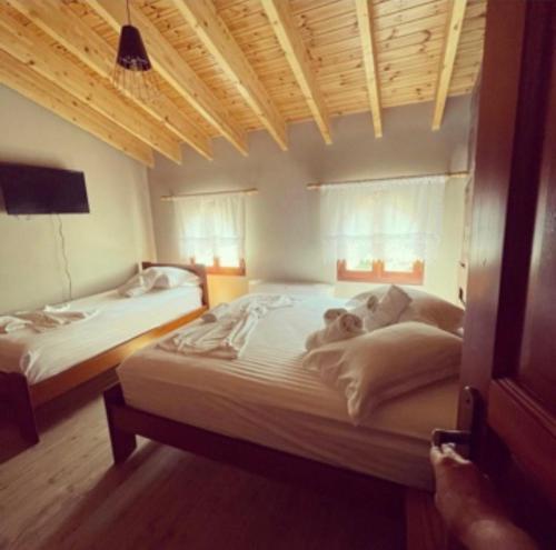 a bedroom with two beds and a tv on the wall at Bujtina Te Xhako in Përmet