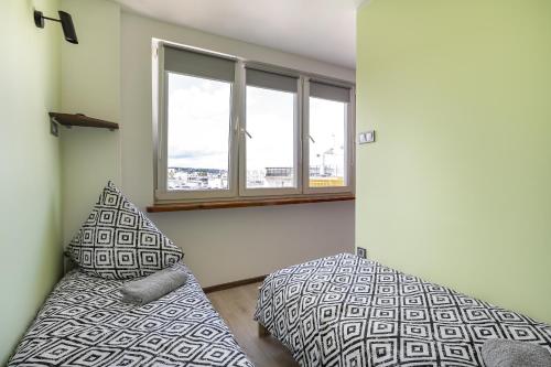 een slaapkamer met 2 bedden en een raam bij 18 Gdynia Centrum - Apartament Mieszkanie dla 4 os in Gdynia