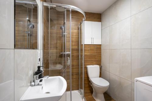 een badkamer met een douche, een toilet en een wastafel bij 18 Gdynia Centrum - Apartament Mieszkanie dla 4 os in Gdynia