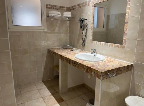 La salle de bains est pourvue d'un lavabo et d'un miroir. dans l'établissement Hôtel Lilium Maris, à Tizzano