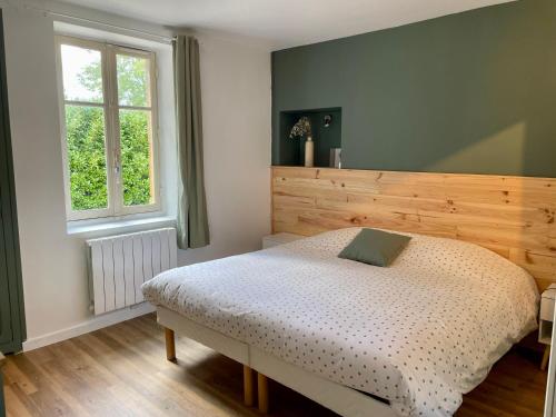 Schlafzimmer mit einem Bett und einem Fenster in der Unterkunft Le gîte du lavoir 