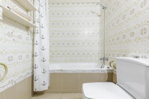 a bathroom with a toilet and a shower curtain at CORTIJO EL LLANO GRAND in Almería