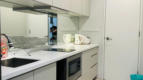 a kitchen with white counters and a sink and a mirror at Panoramic KL View @Robertson Bukit Bintang 40f in Kuala Lumpur