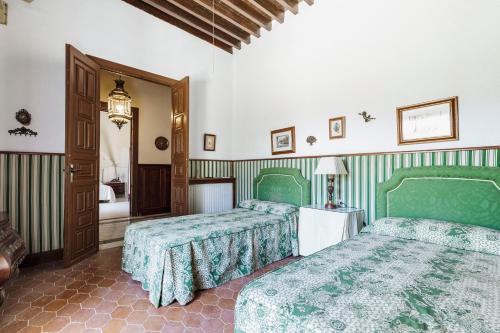 a bedroom with two green beds and a hallway at CORTIJO EL LLANO GRAND in Almería