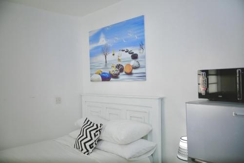 Cette chambre dispose d'un canapé blanc avec une photo sur le mur. dans l'établissement Nairobi Affordable studio apartments hosted by Lilian, à Nairobi