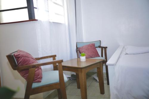 - une chambre avec une table, deux chaises et un lit dans l'établissement Nairobi Affordable studio apartments hosted by Lilian, à Nairobi