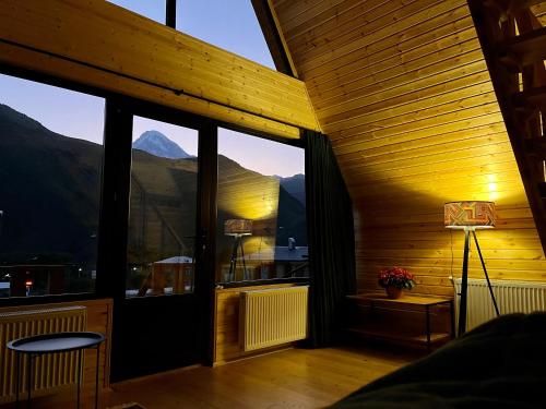 a room with a large window with a view of a mountain at Cottage Carpe Diem in Stepantsminda