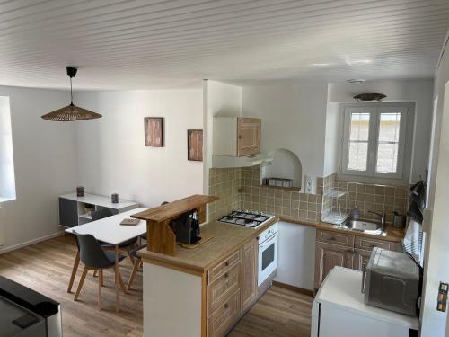 une cuisine avec une table et une cuisinière four supérieur dans l'établissement Le gîte du lavoir, à Limon