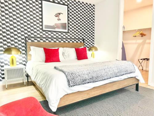 Un dormitorio con una cama con almohadas rojas y una pared a cuadros. en Hidden Gem Apartment In Downtown, en San Diego