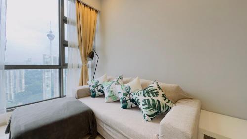 a couch with pillows on it in a room with a window at Panoramic KL View @Robertson Bukit Bintang 40f in Kuala Lumpur