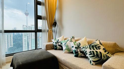 a living room with a couch with pillows and a window at Panoramic KL View @Robertson Bukit Bintang 40f in Kuala Lumpur