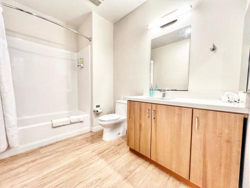 Un baño con lavabo, inodoro y espejo. en Hidden Gem Apartment In Downtown, en San Diego