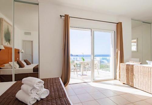 una camera d'albergo con un letto e una grande finestra di Hôtel Lilium Maris a Tizzano