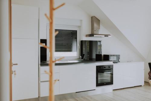 a kitchen with white cabinets and a stove top oven at MY HOME ADDL in Štrigova