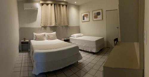 a hotel room with two beds and a window at Center Plaza Hotel in Caruaru