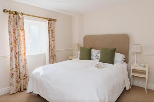 1 dormitorio con 1 cama blanca grande con almohadas verdes en Coach House - 4 Bedroom Self-Catering, en Preston