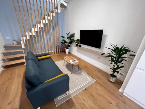 ein Wohnzimmer mit einem blauen Sofa und einem TV in der Unterkunft Residence Terrazza Perez - appartamento indipendente in Foggia