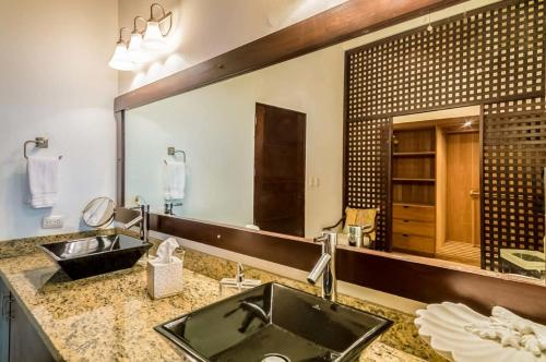 baño con lavabo y espejo grande en Sunny vacation Villa No 67 en San Rafael del Yuma