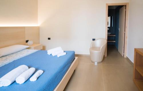 a bedroom with a blue bed with two white towels at Isola Verde in Casal Velino