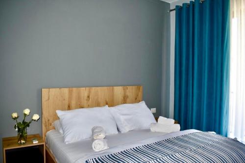a bedroom with a bed with a blue curtain at Olive House in Golem